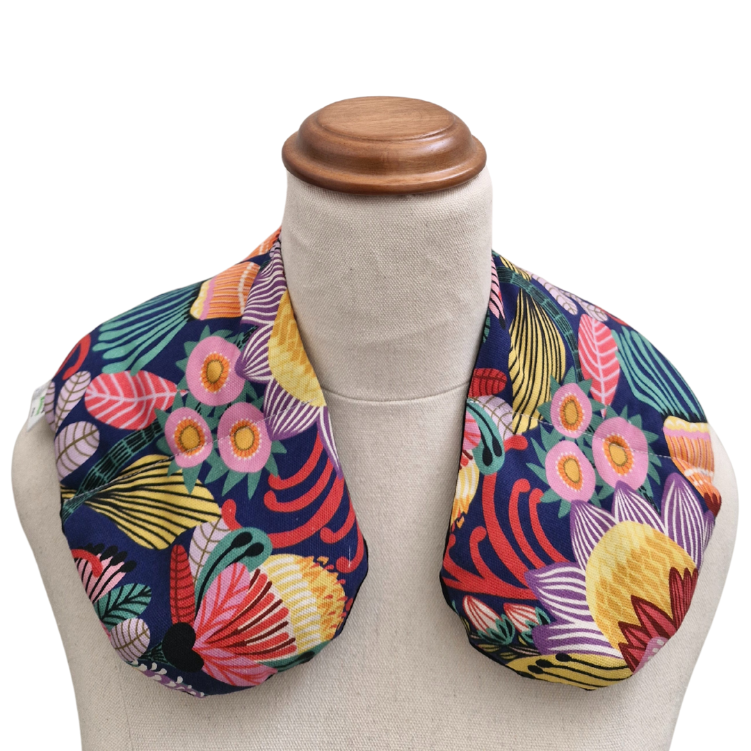 Colourful Australian floral neck heat pack filled with lupin seeds, worn across the shoulders for hot or cold therapy