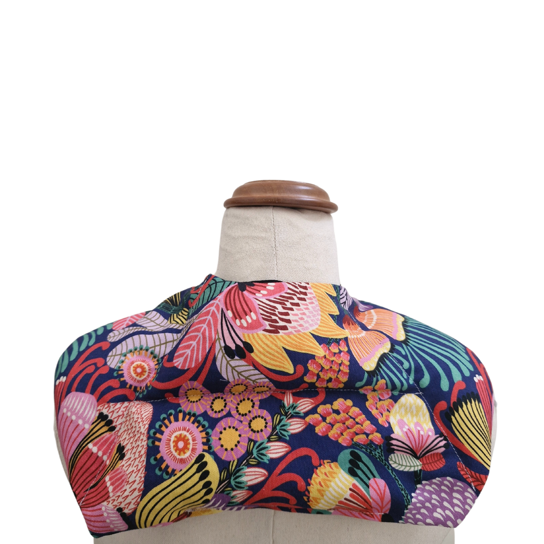 Colourful Australian floral neck heat pack filled with lupin seeds, worn across the shoulders for hot or cold therapy