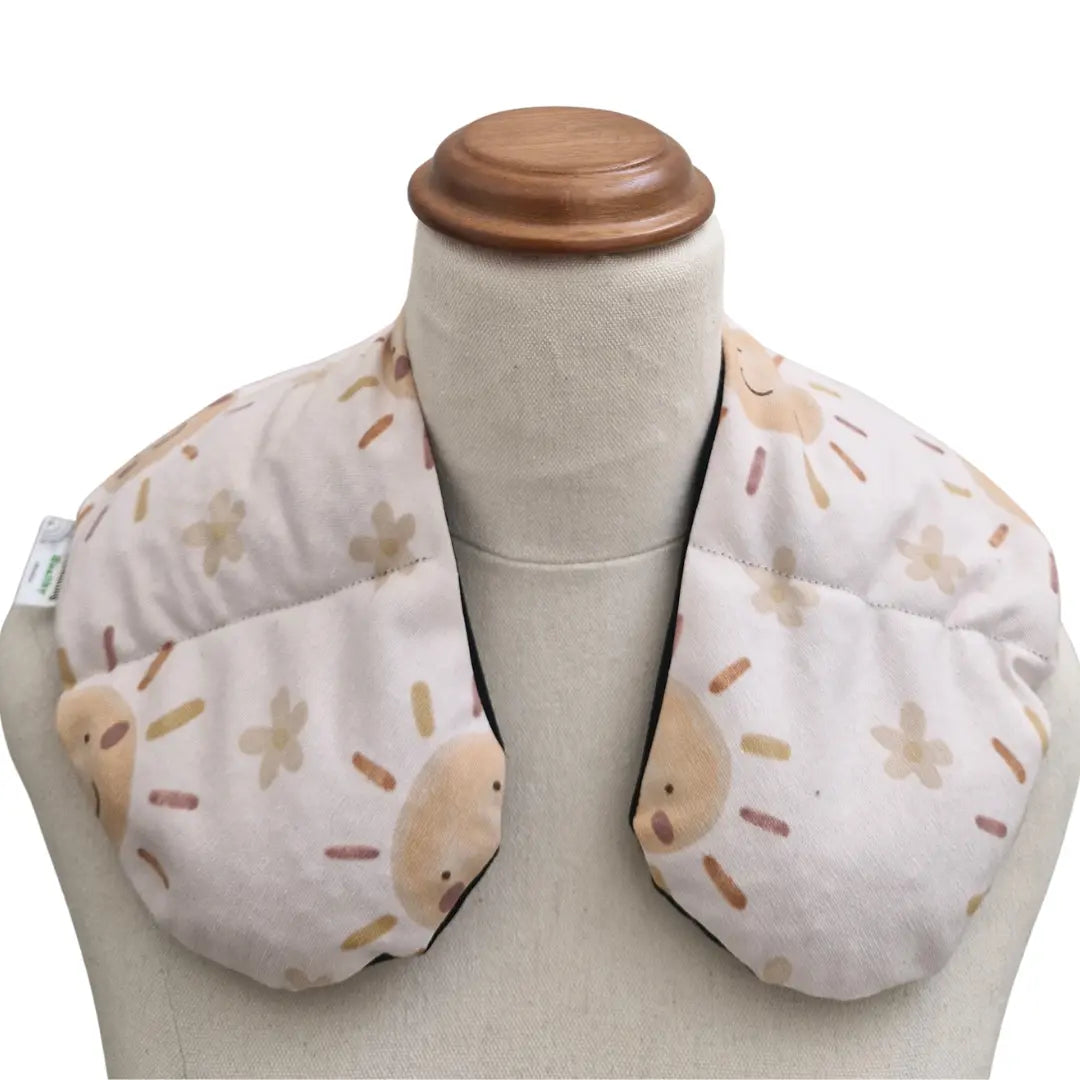 Happy sun neck heat pack filled with lupin seeds, worn across the shoulders for hot or cold therapy